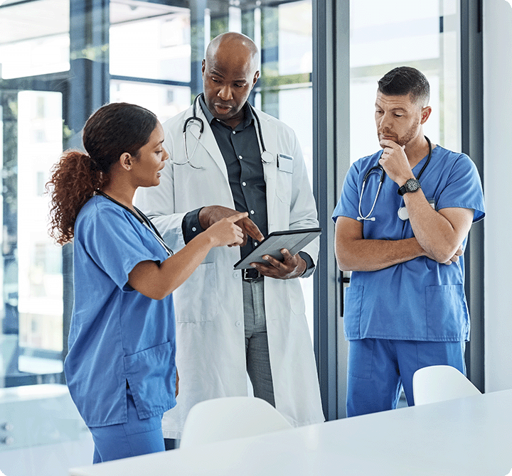 Three doctors discussing operations while using a FirstNet device 