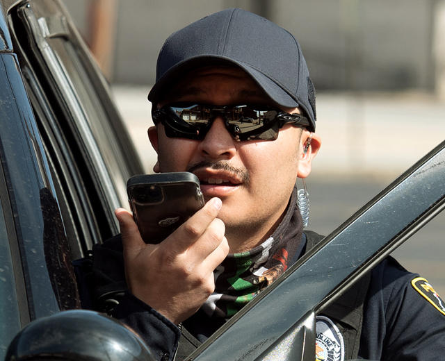 Police officer talking into a phone speaker