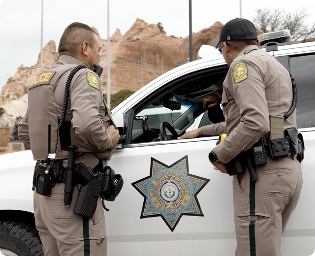 Two navajo nation officer standing near police cruiser 