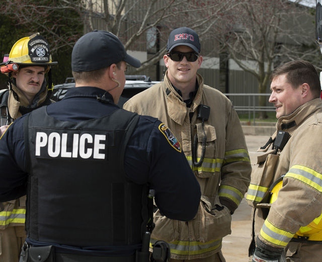 Group of  firefighters talking to police officer
